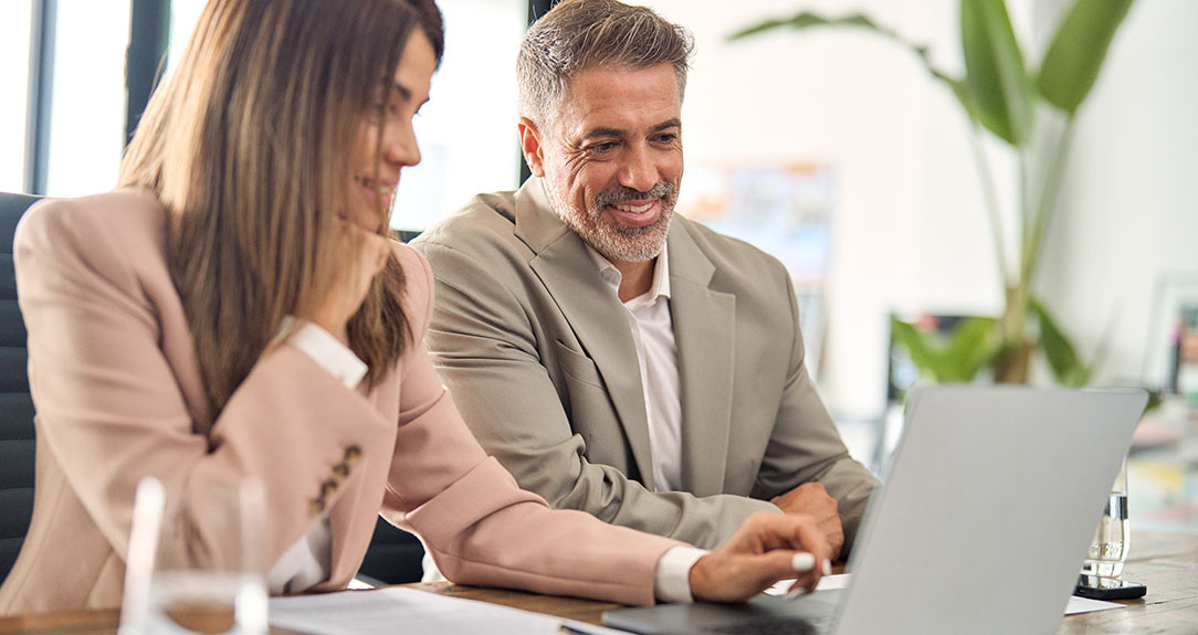 Man looking at laptop with marketing professional